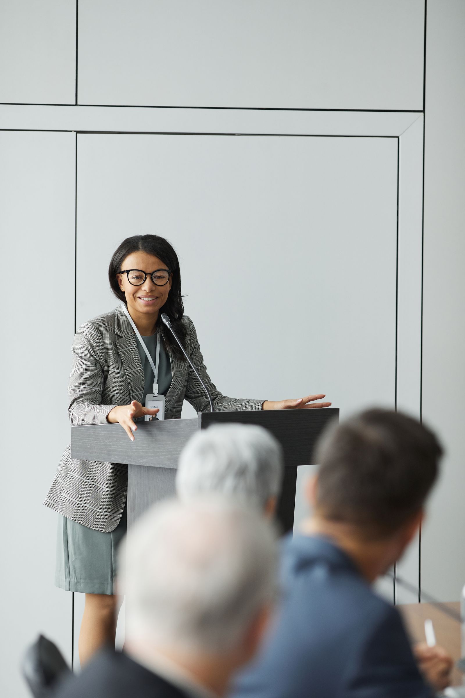 A woman in a grey blazer talking to a small group